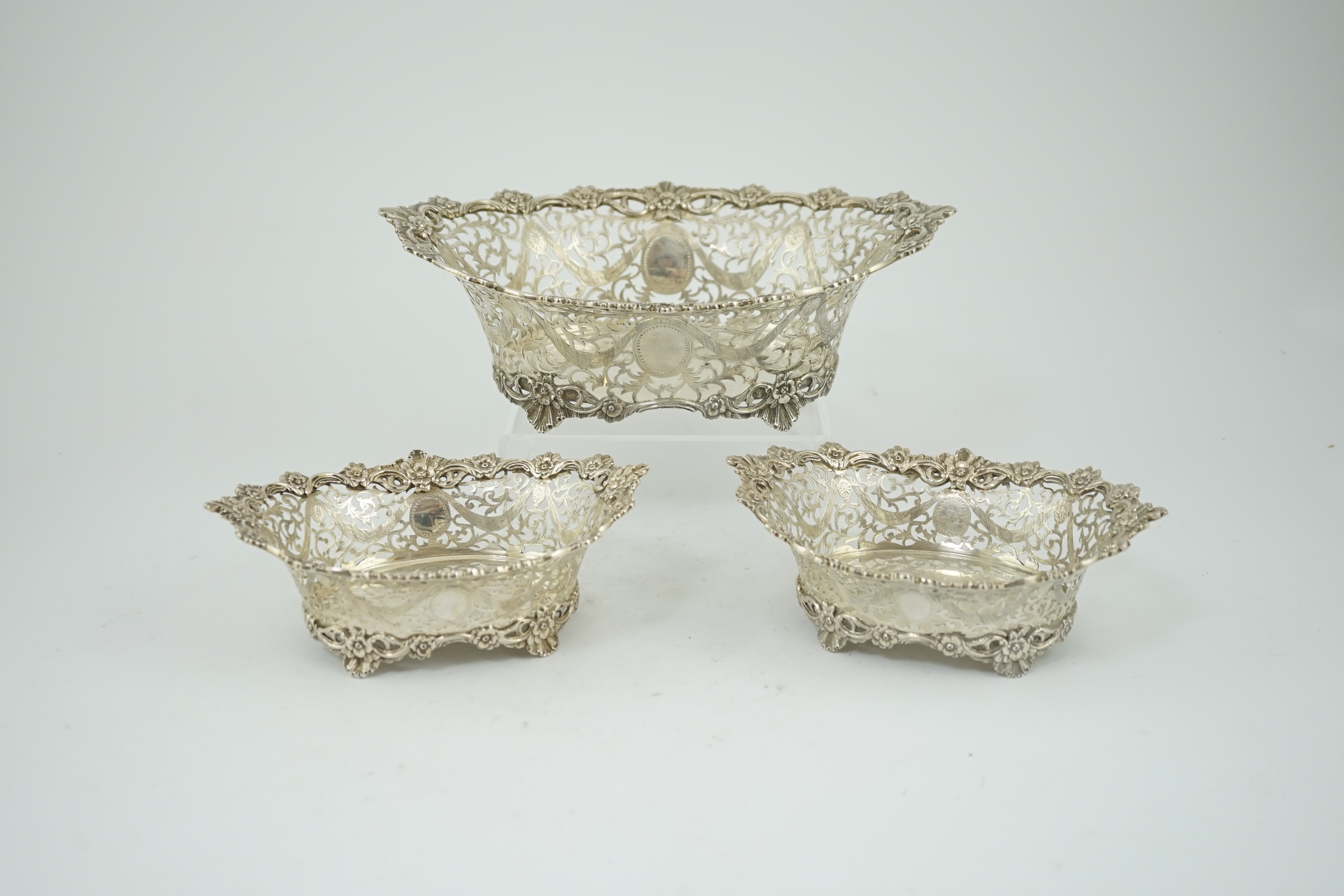 A graduated suite of three George V pierced silver oval bowls, by Charles Stuart Harris & Sons